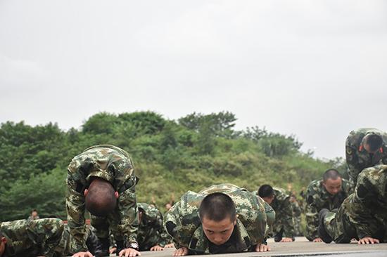 体能训练中，很多战友已经支撑不住，但孔文（中）还在不懈坚持，做好每一个俯卧撑